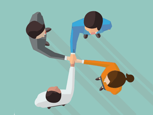 four business people holding hands in circle