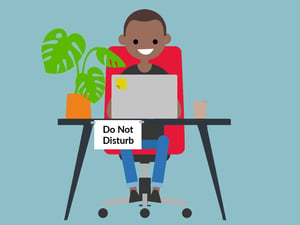 Recruiter working at home with a sign that says 'do not disturb' stuck to his desk.
